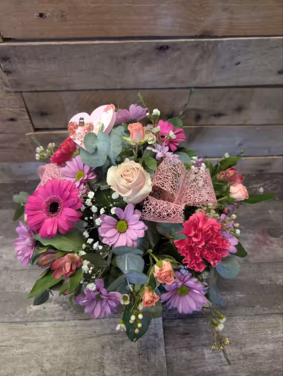 Close up of pink roses and seasonal flowers in a Mother’s Day hat box arrangement